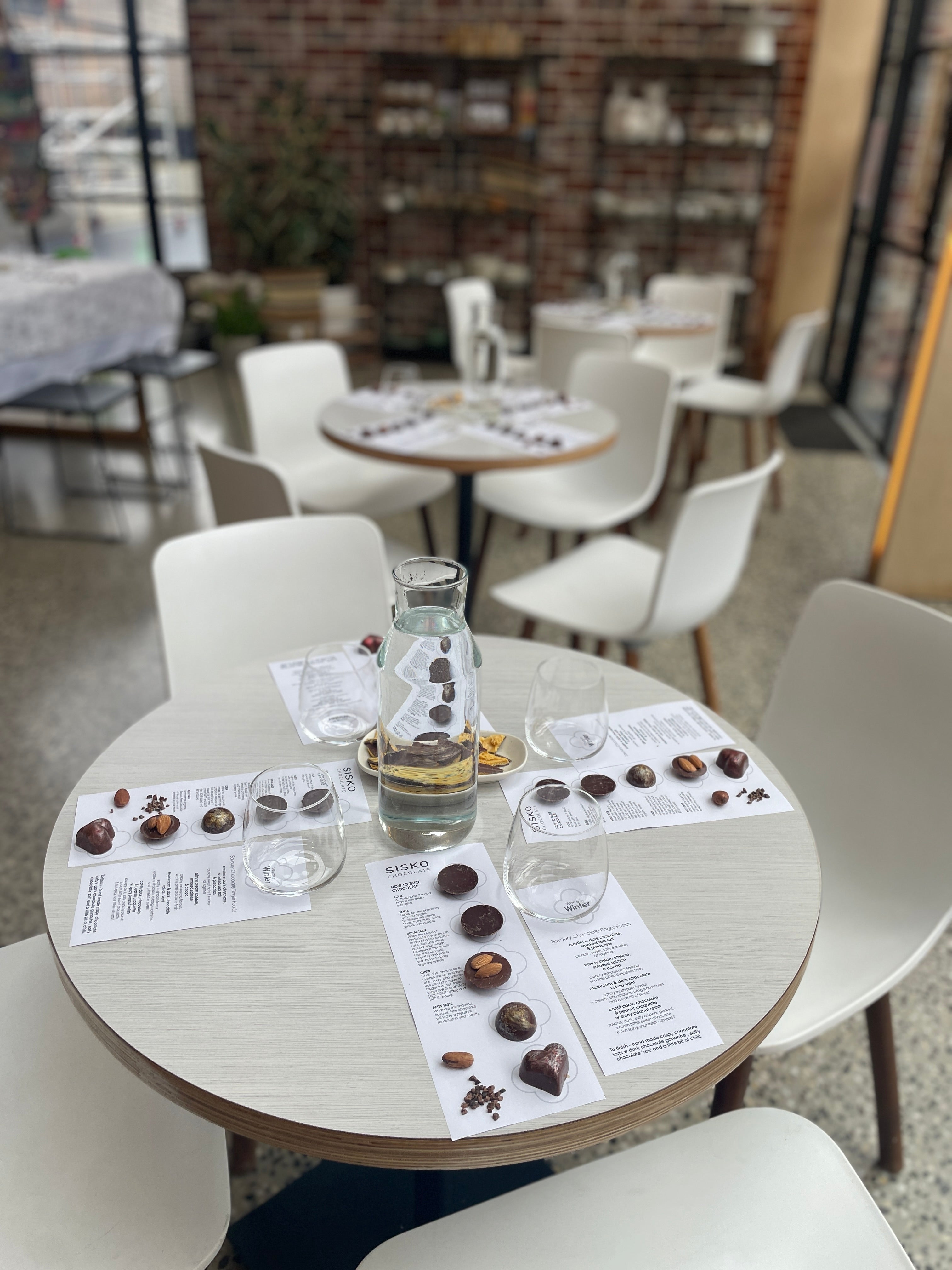 Round table with chocolate samples and glasses in a restaurant setting