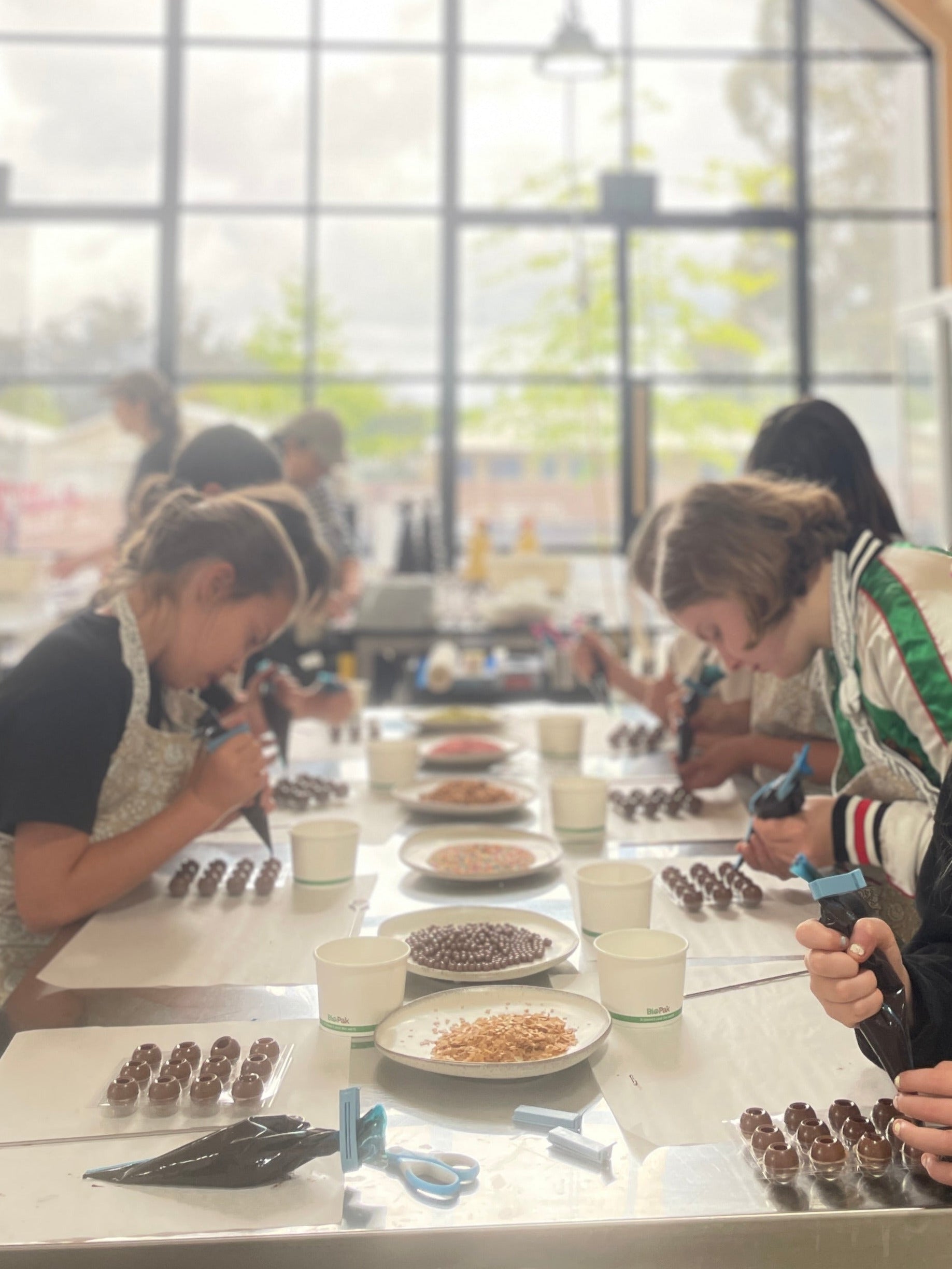 Students in a modern classroom setting with large windows.